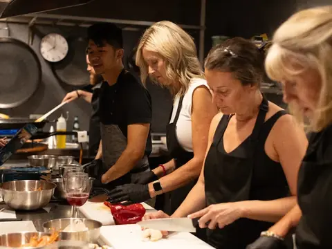 Guests chopping and stirring together in the cooking class kitchen