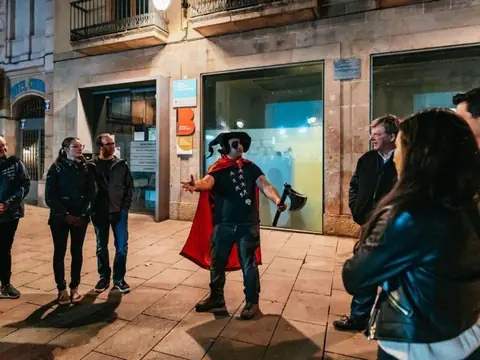 A guide in costume telling a story to the group at night