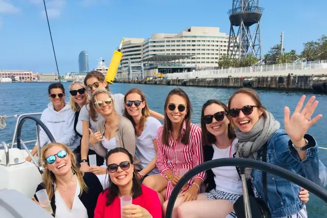 Friends smiling on the deck of a yacht in Barcelona